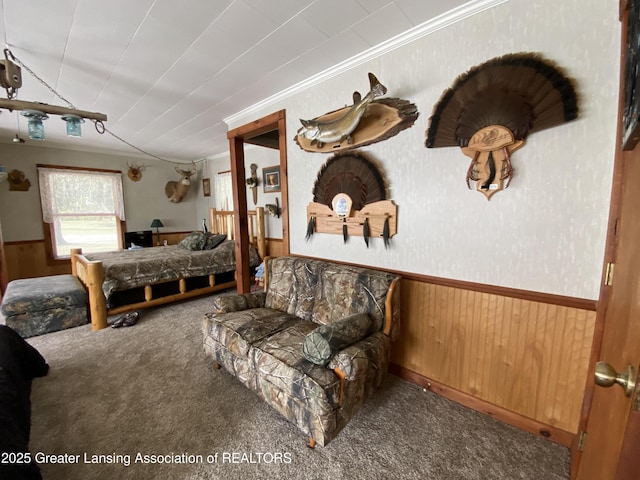 bedroom with crown molding, carpet floors, a wainscoted wall, and wood walls