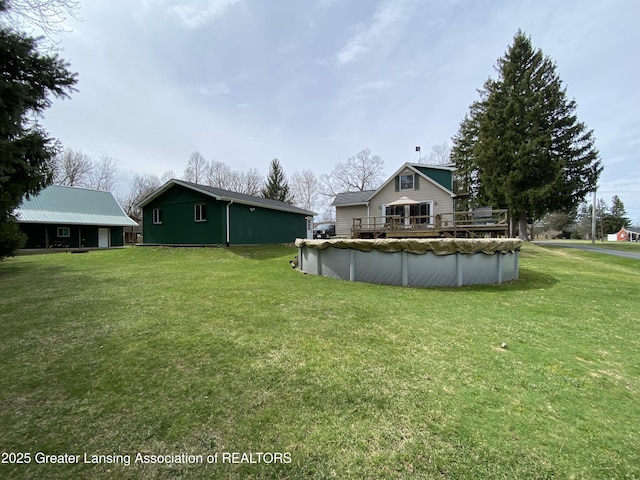 view of yard featuring a deck and a covered pool
