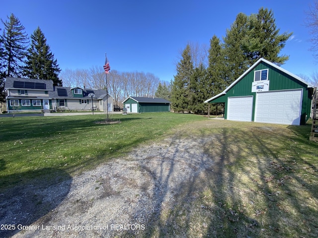 view of yard featuring a garage and an outdoor structure