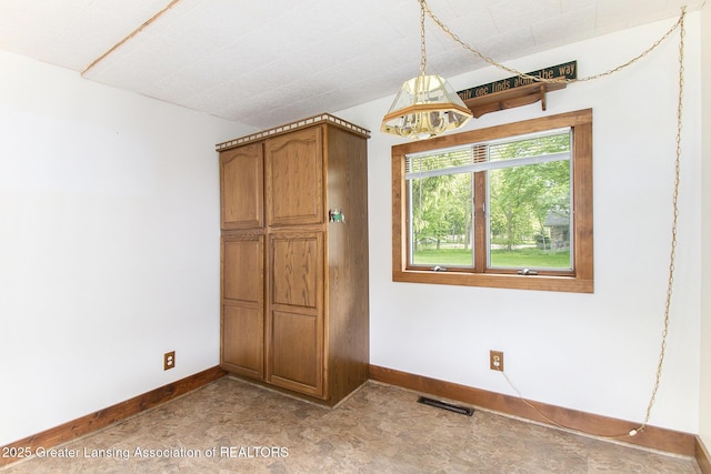 1588 N Chipman Rd, Owosso, MI 48867 - unfurnished bedroom with baseboards and a chandelier