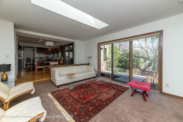 1210 Whittier Dr, East Lansing, MI 48823 - carpeted living room featuring a skylight and baseboards