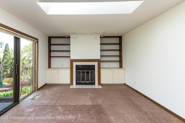 1210 Whittier Dr, East Lansing, MI 48823 - unfurnished living room featuring a skylight, light colored carpet, visible vents, and a tile fireplace