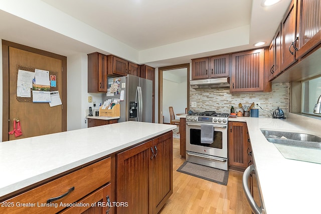1210 Whittier Dr, East Lansing, MI 48823 - kitchen with a sink, light countertops, stainless steel appliances, backsplash, and under cabinet range hood