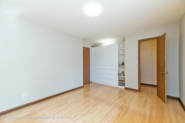 1210 Whittier Dr, East Lansing, MI 48823 - unfurnished bedroom with baseboards, a closet, light wood-style flooring, and visible vents