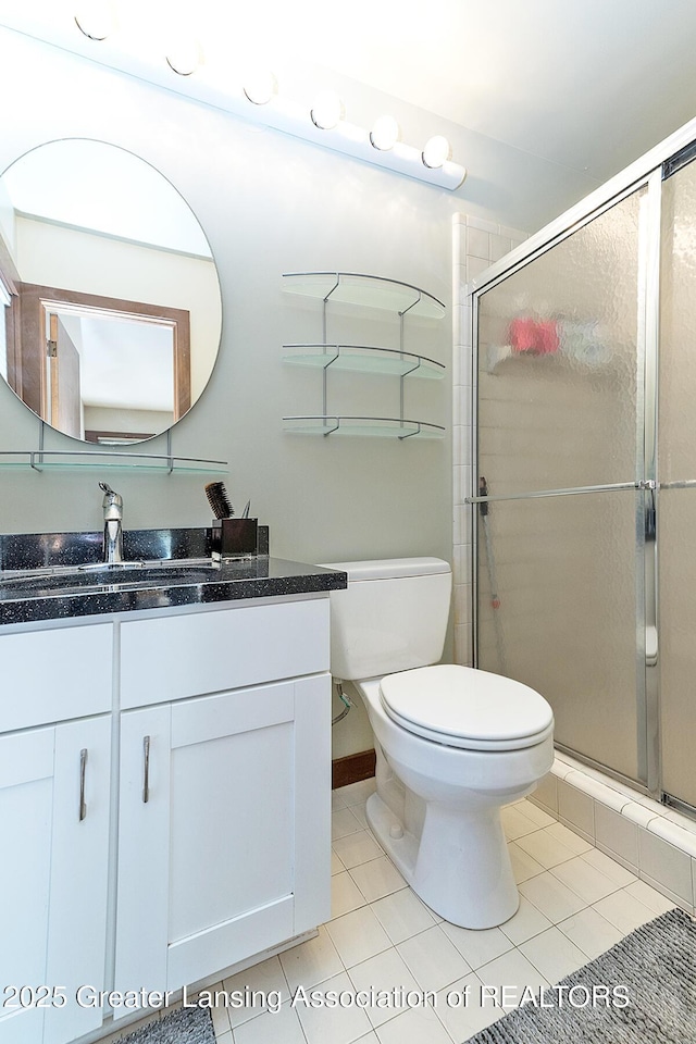 1210 Whittier Dr, East Lansing, MI 48823 - full bathroom featuring toilet, tile patterned floors, a shower stall, and vanity