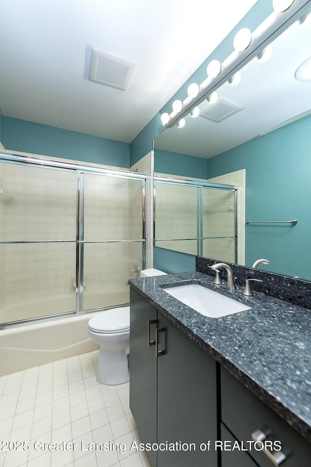 1210 Whittier Dr, East Lansing, MI 48823 - bathroom featuring vanity, toilet, tile patterned floors, combined bath / shower with glass door, and visible vents