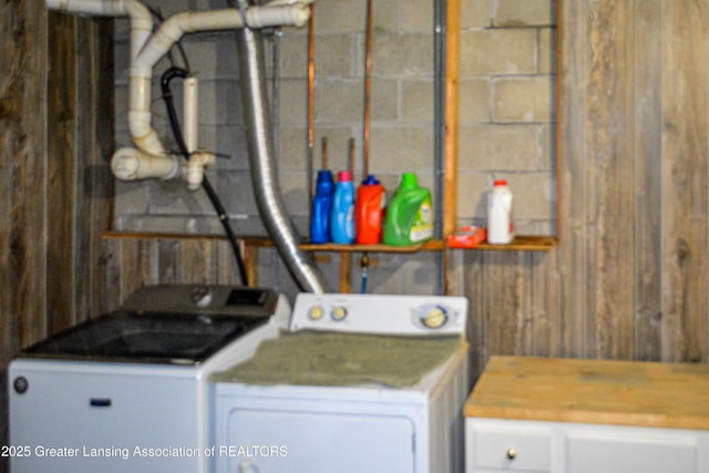 laundry area featuring washer and clothes dryer, laundry area, and concrete block wall