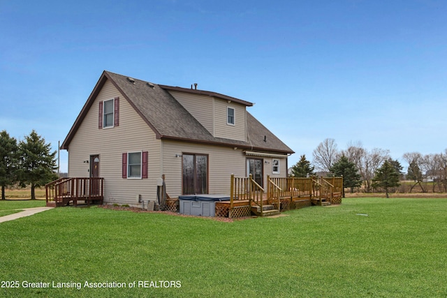 back of property featuring a yard, a shingled roof, a wooden deck, and a hot tub
