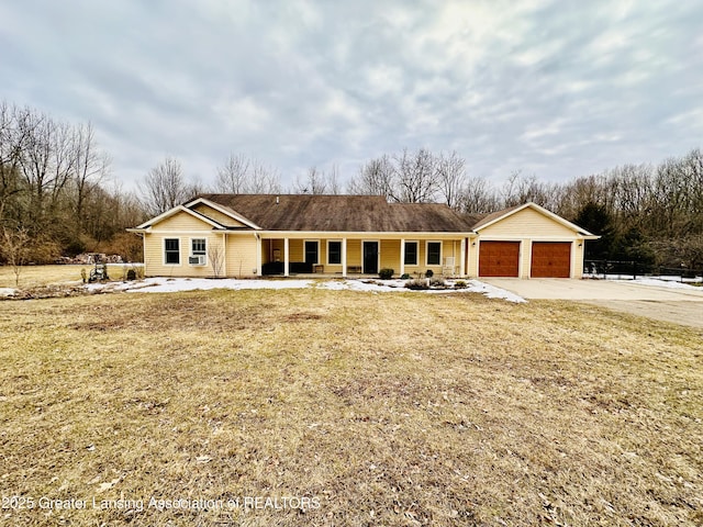 ranch-style home with an attached garage, covered porch, a front lawn, and concrete driveway