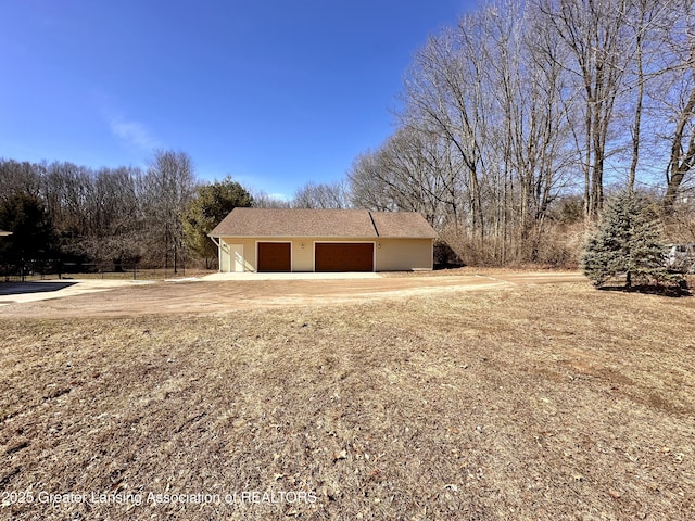 detached garage featuring dirt driveway