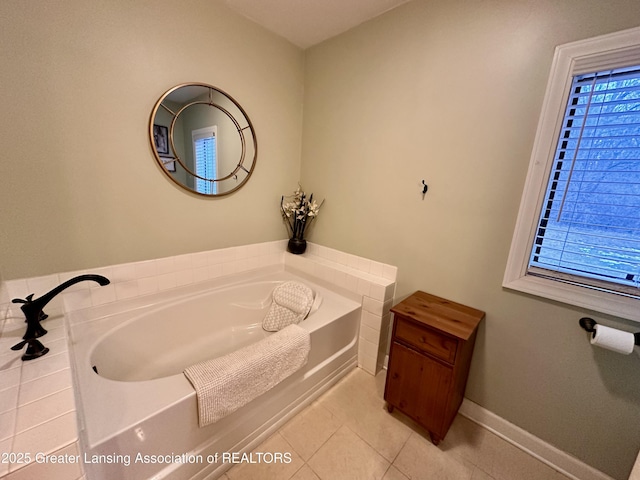 full bath featuring tile patterned floors, baseboards, and a garden tub