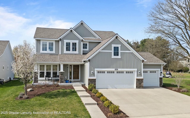 craftsman-style home with a shingled roof, concrete driveway, board and batten siding, covered porch, and a front yard