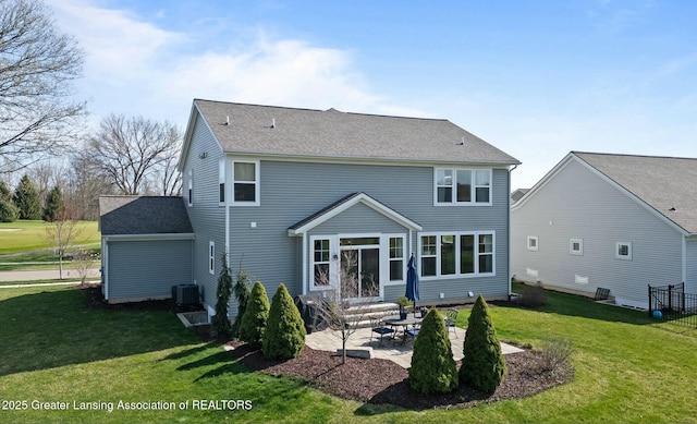 rear view of property featuring a yard, central AC, a patio, and a shingled roof