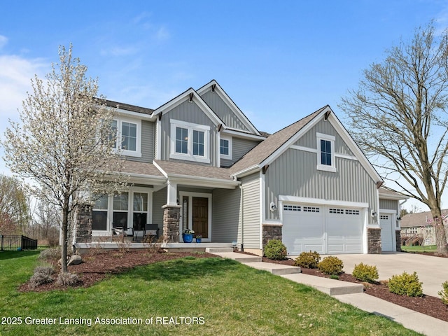 craftsman inspired home with stone siding, concrete driveway, covered porch, board and batten siding, and a front yard