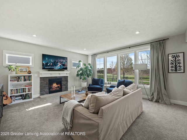 carpeted living room with recessed lighting, baseboards, a fireplace, and a textured ceiling