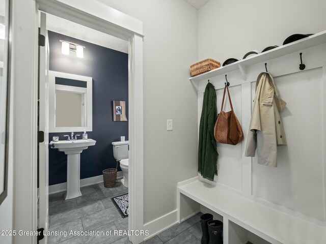 mudroom featuring tile patterned floors and baseboards
