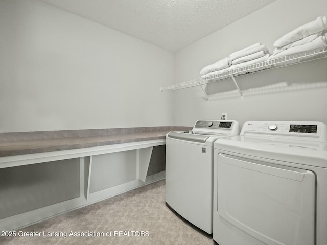 laundry area featuring light floors, independent washer and dryer, a textured ceiling, and laundry area