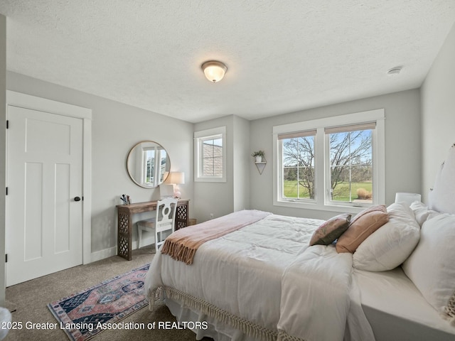 bedroom with baseboards, carpet floors, and a textured ceiling
