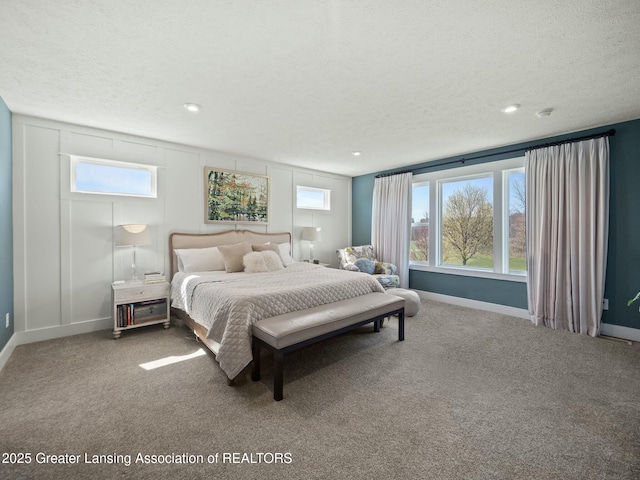 bedroom featuring baseboards, a textured ceiling, and carpet