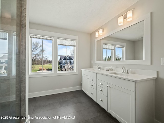 full bathroom with tile patterned floors, baseboards, a sink, and double vanity