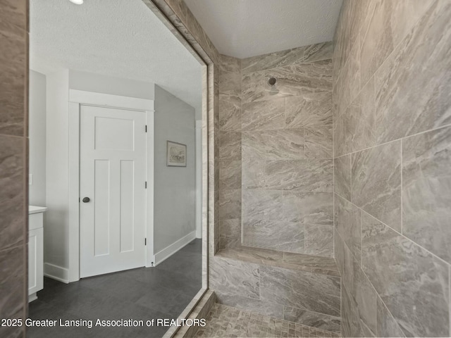 full bath featuring a textured ceiling and baseboards
