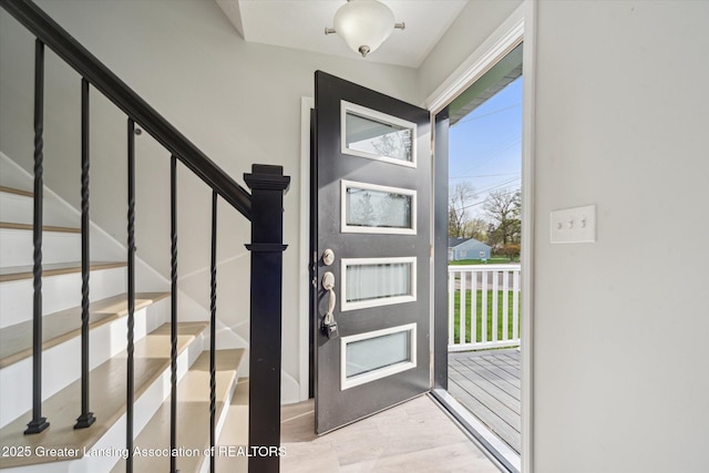 foyer with wood finished floors and stairs