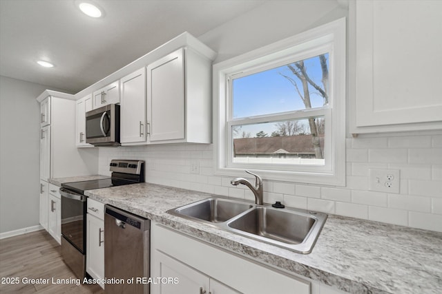 kitchen featuring white cabinets, appliances with stainless steel finishes, and a sink