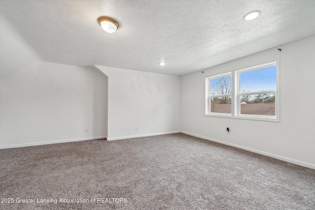 empty room featuring carpet, baseboards, a textured ceiling, and recessed lighting