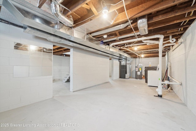 unfinished basement featuring heating unit, electric water heater, and washer / dryer