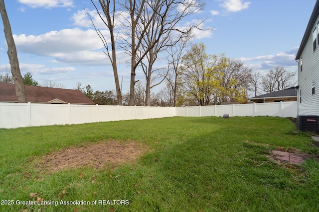 view of yard with fence and central AC unit