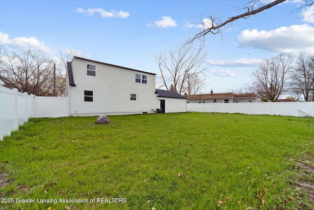 rear view of property with a lawn and a fenced backyard