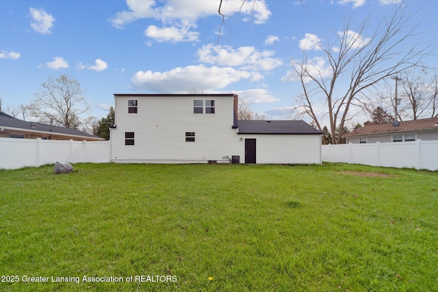 back of property with a lawn and a fenced backyard