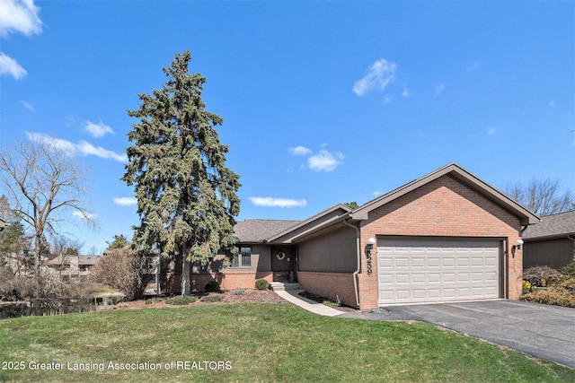 single story home featuring brick siding, a front yard, aphalt driveway, and a garage