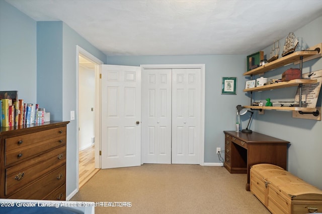interior space featuring a closet, baseboards, and light carpet