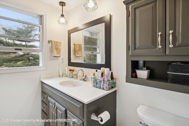 bathroom with a wealth of natural light, vanity, and toilet