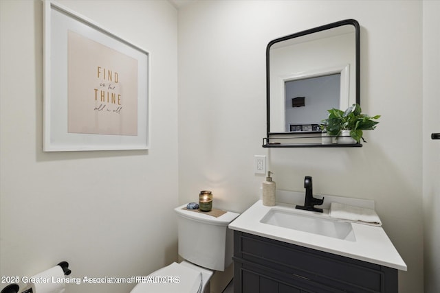 half bathroom with vanity and toilet