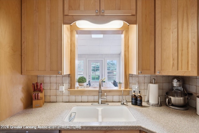 kitchen with a sink, light countertops, and tasteful backsplash
