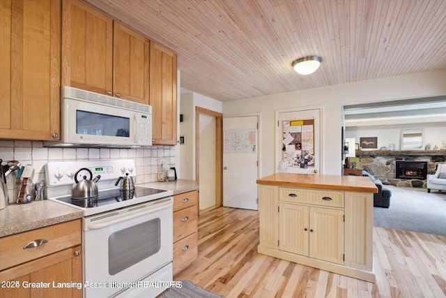 kitchen with tasteful backsplash, open floor plan, light wood finished floors, and white appliances
