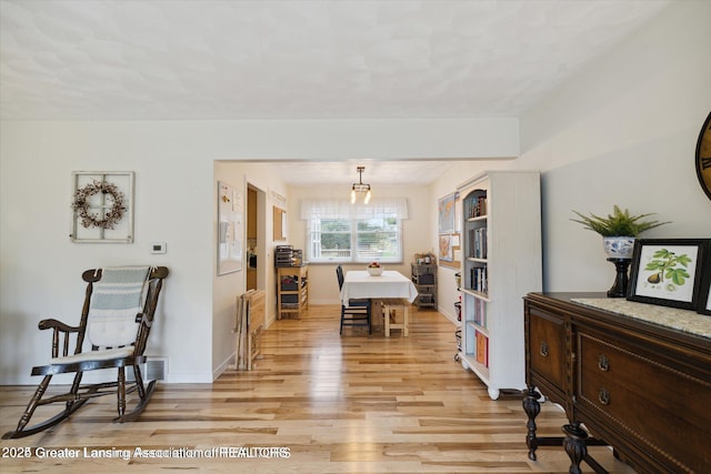 dining area with light wood finished floors and baseboards