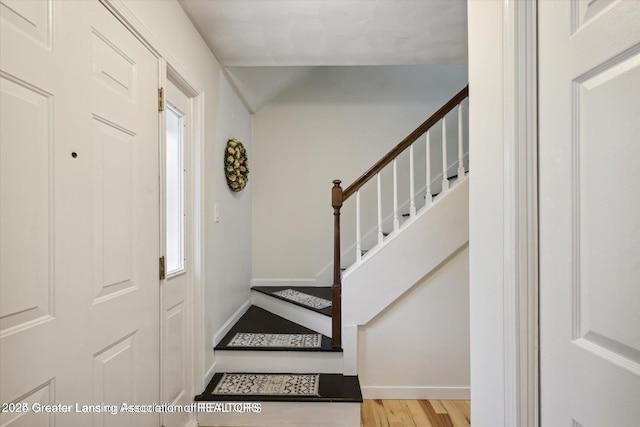 entrance foyer featuring stairway, baseboards, and wood finished floors