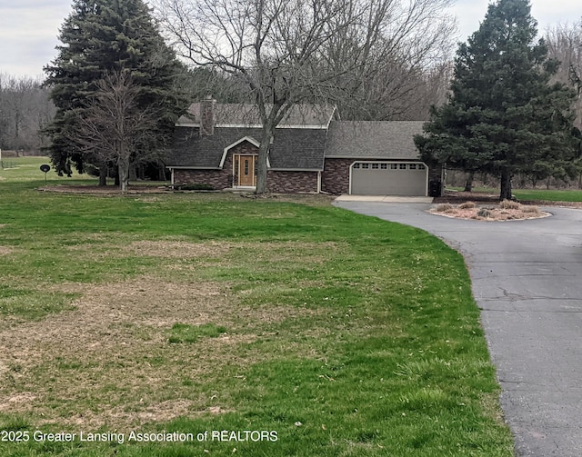 view of front of house with a garage, a chimney, a front lawn, driveway, and roof with shingles