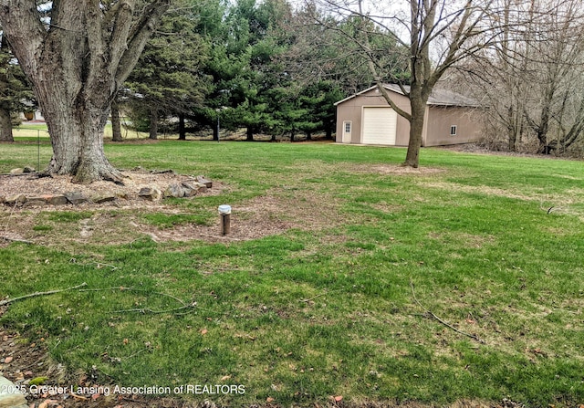 view of yard with a garage and an outdoor structure