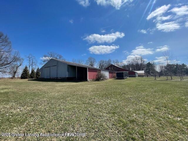 11100 Anderson Rd, Litchfield, MI 49252 - view of property exterior featuring a pole building, a lawn, and an outbuilding