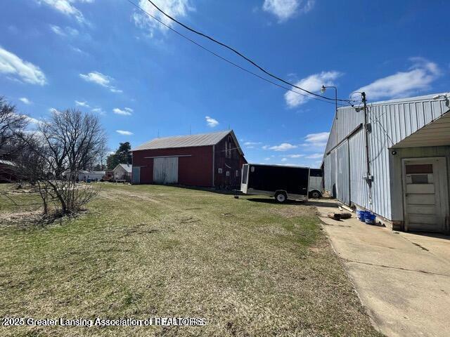 11100 Anderson Rd, Litchfield, MI 49252 - view of green lawn featuring a pole building, driveway, and an outdoor structure