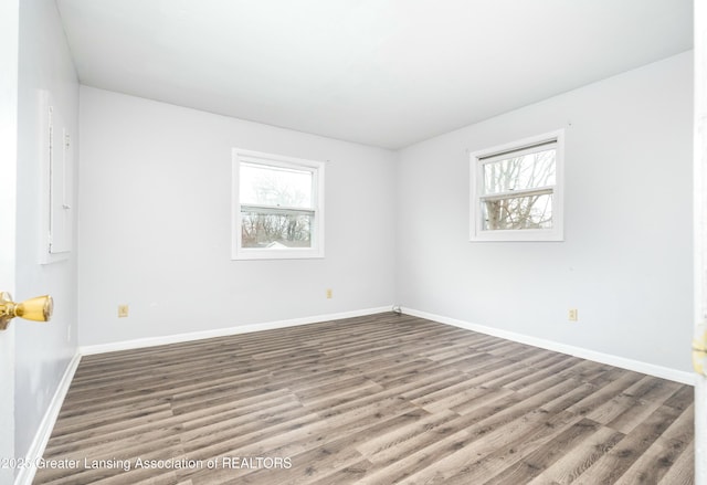 5026 Delray Dr, Lansing, MI 48910 - empty room featuring wood finished floors, baseboards, and plenty of natural light