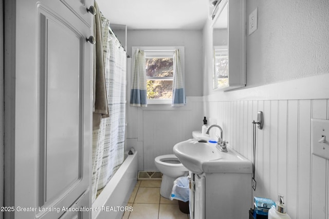 610 Spokane Ave, Lansing, MI 48910 - full bath with a wainscoted wall, tile patterned floors, toilet, vanity, and shower / bath combo with shower curtain