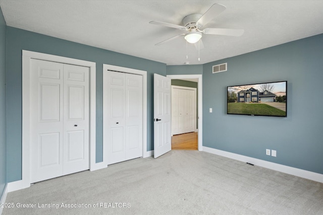 3430 Hawthorne Woods Pkwy, Dewitt, MI 48820 - unfurnished bedroom featuring visible vents, baseboards, two closets, ceiling fan, and carpet flooring