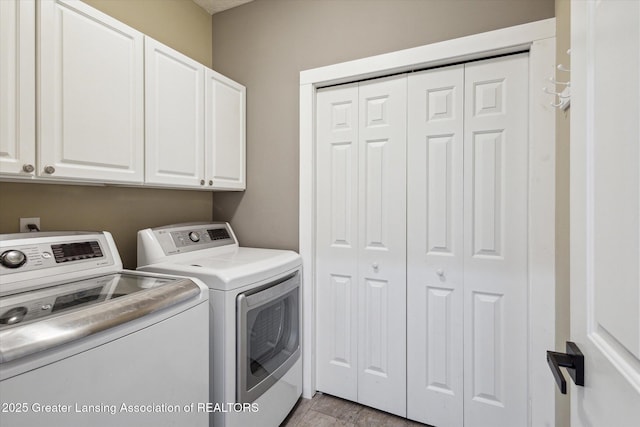 3430 Hawthorne Woods Pkwy, Dewitt, MI 48820 - laundry area featuring light wood-type flooring, washing machine and dryer, and cabinet space
