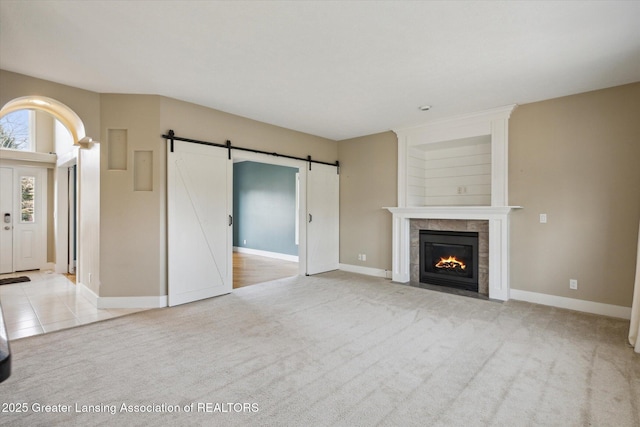 3430 Hawthorne Woods Pkwy, Dewitt, MI 48820 - unfurnished living room with a fireplace, a barn door, light colored carpet, and baseboards