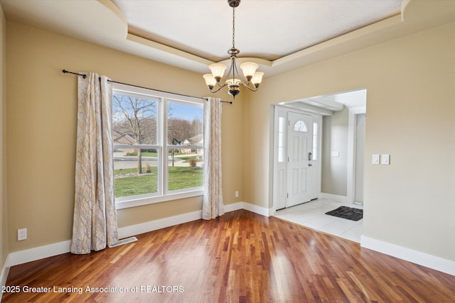 3430 Hawthorne Woods Pkwy, Dewitt, MI 48820 - foyer with a tray ceiling, baseboards, a chandelier, and wood finished floors